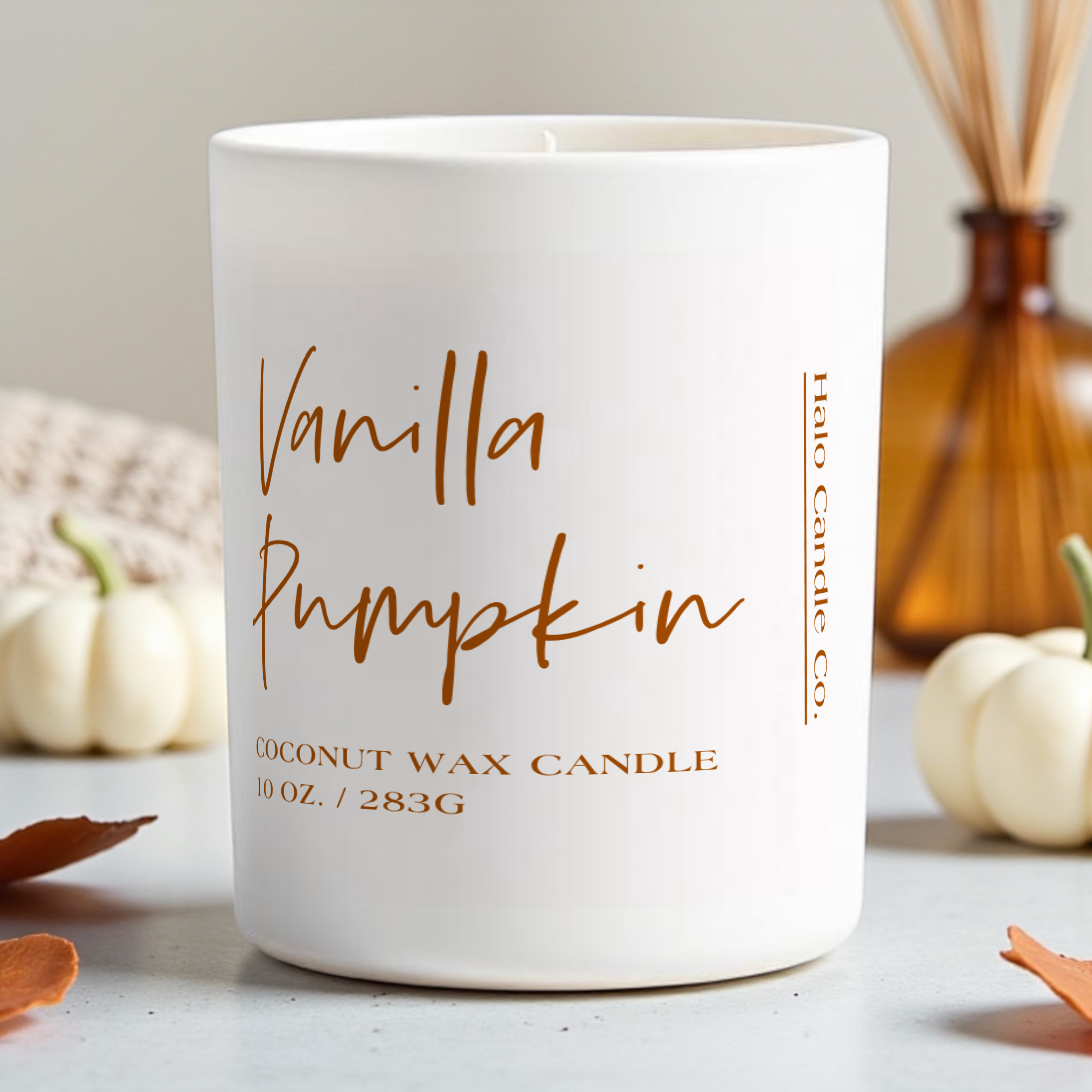 Hand-poured fall candles in cozy autumn scents like pumpkin waffles, vanilla pumpkin, bonfire, and apple—displayed with seasonal decor in a warm, inviting setting.